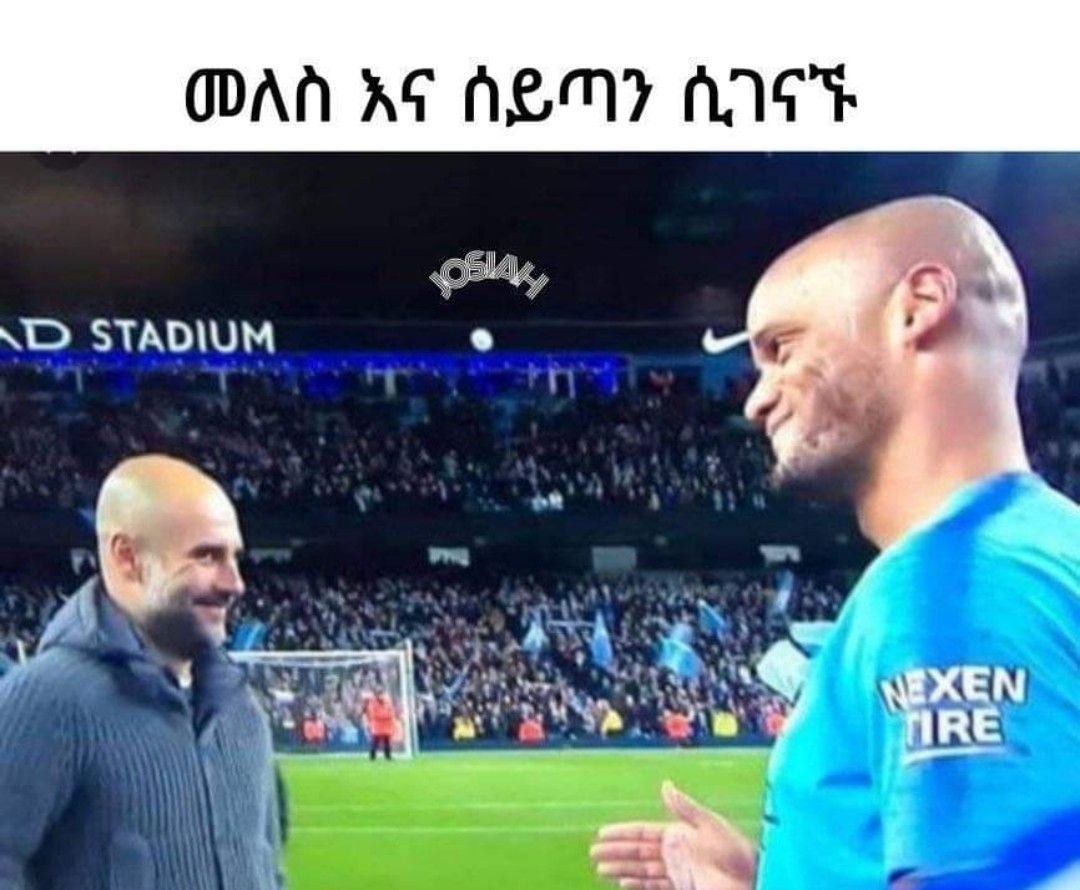 a man in a blue shirt talking to another man in a blue shirt